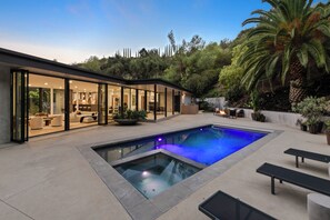 Alberca al aire libre y camastros 