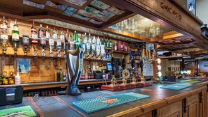 Un bar con mostrador de madera, varias botellas de licor y un grifo de cerveza Guinness.