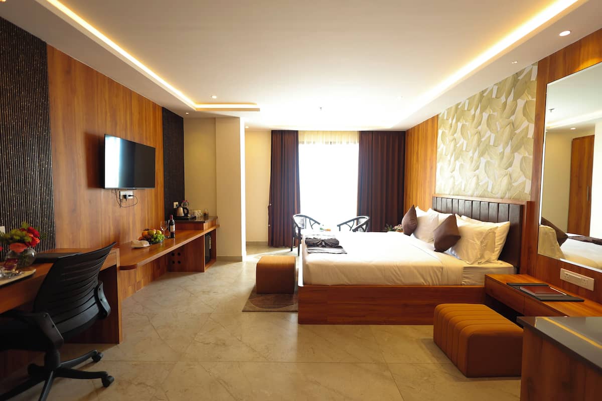 Une chambre d’hôtel moderne équipée d’un lit, d’un bureau et d’un coin salon.