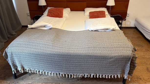 A double bed with a headboard, two bedside lamps, and a blanket. - Smart 1BR Apt Near Westbahnhof Station (Vienna)