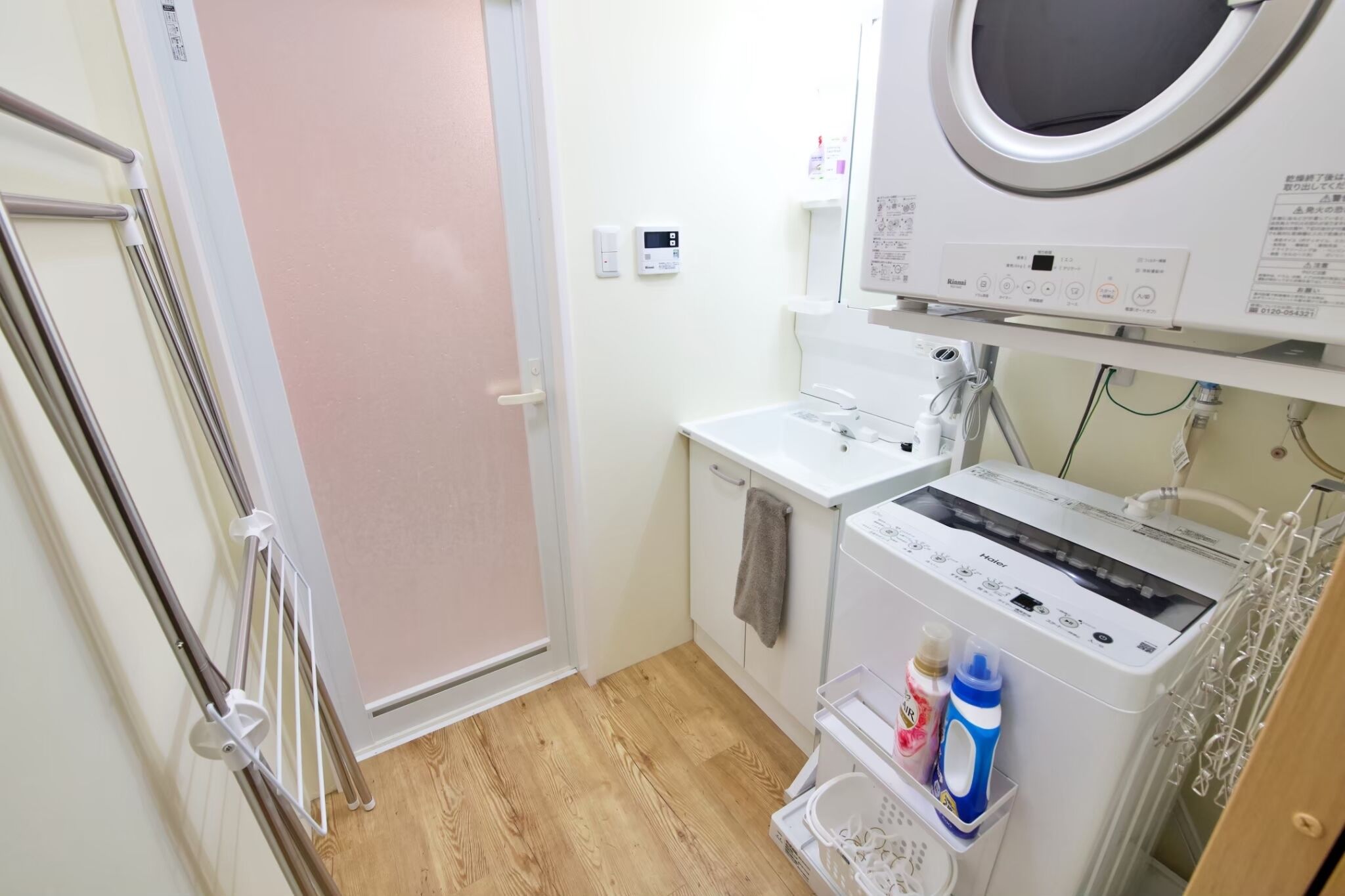 A compact laundry room with a washing machine, a dryer, and a small sink.