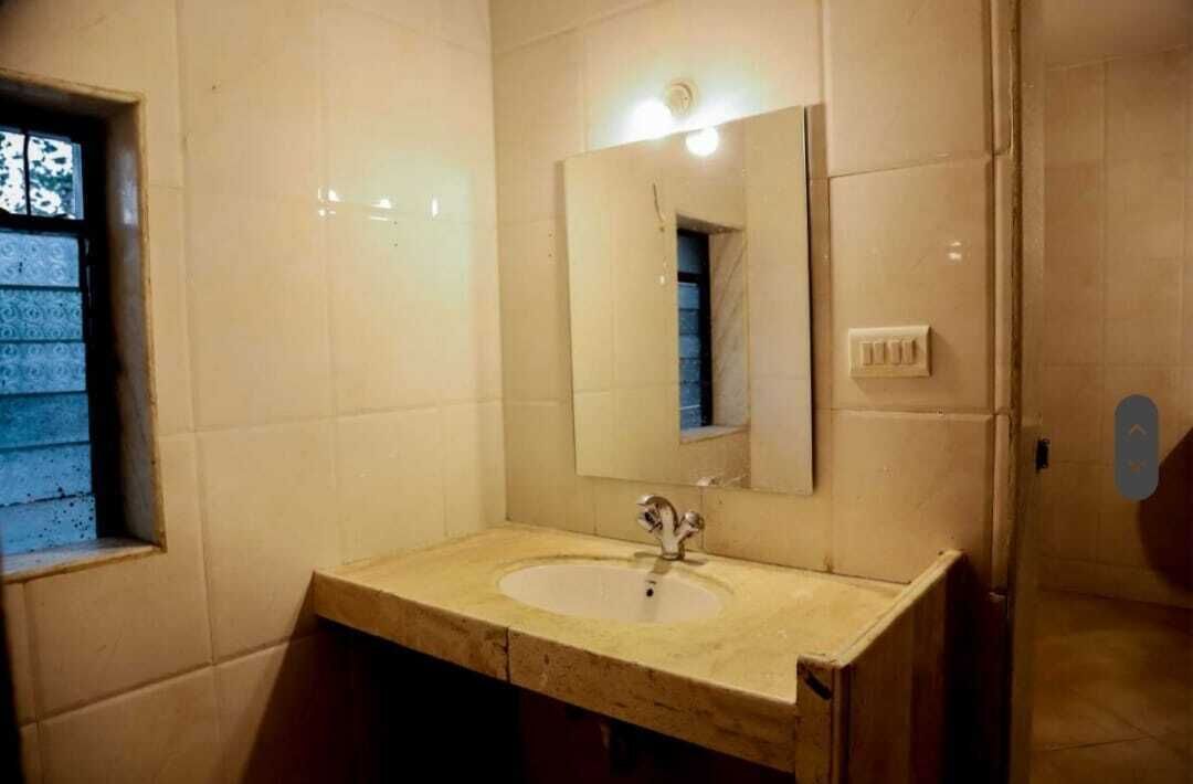 A bathroom with a sink, mirror, and window.