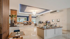 Una cocina moderna con una isla central, electrodomésticos integrados y una zona de comedor con mesa y sillas.