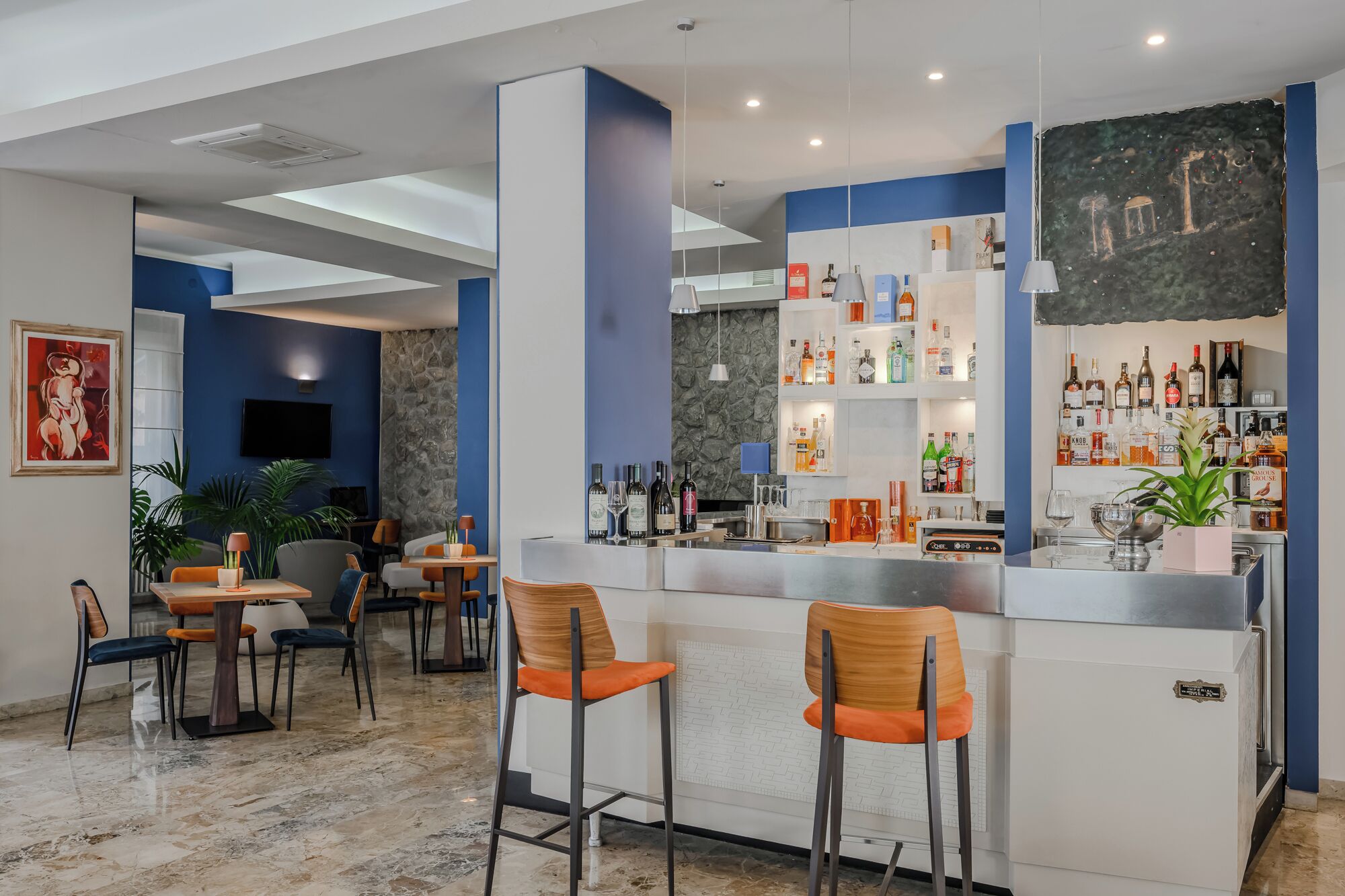 A bar area with a counter, seating, and a stone wall.