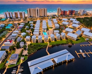 A coastal resort with multiple buildings, a marina, and a swimming pool.