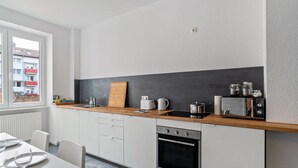 A modern kitchen with a wooden countertop, built-in oven, and a view of a building outside. - Entire 'Hallerstraße' Unit with 4 Apartments, Balcony and Wi-Fi (Pforzheim)