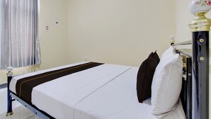 A room with a bed, a nightstand, a lamp, and a window with curtains. - OYO 94841 Alodia Homestay Family (Kejajar)