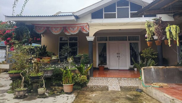 A house with a tiled entrance, potted plants, and a hanging plant decoration. - OYO 94841 Alodia Homestay Family (Kejajar)