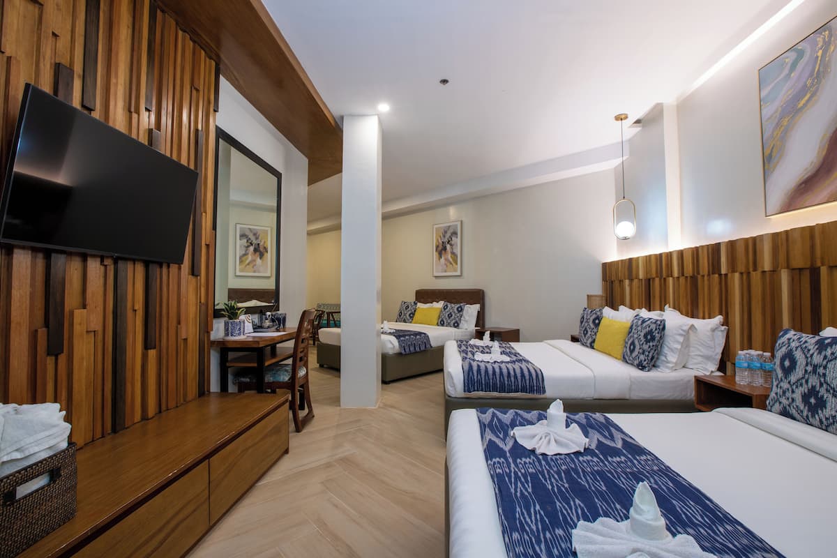 A hotel room with two beds, a TV, a desk, and a chair.
