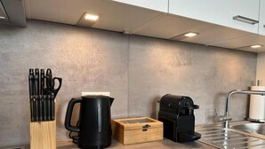A modern kitchen with a coffee maker, a kettle, and a knife block on the counter. - SUITE4ME - Balcony I Kitchen I Washing machine I Mainz-Kostheim (Wiesbaden)