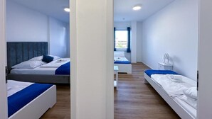 A modern hotel room with two single beds, a small desk, and a window with curtains. - SUITE4ME - Balcony I Kitchen I Washing machine I Mainz-Kostheim (Wiesbaden)
