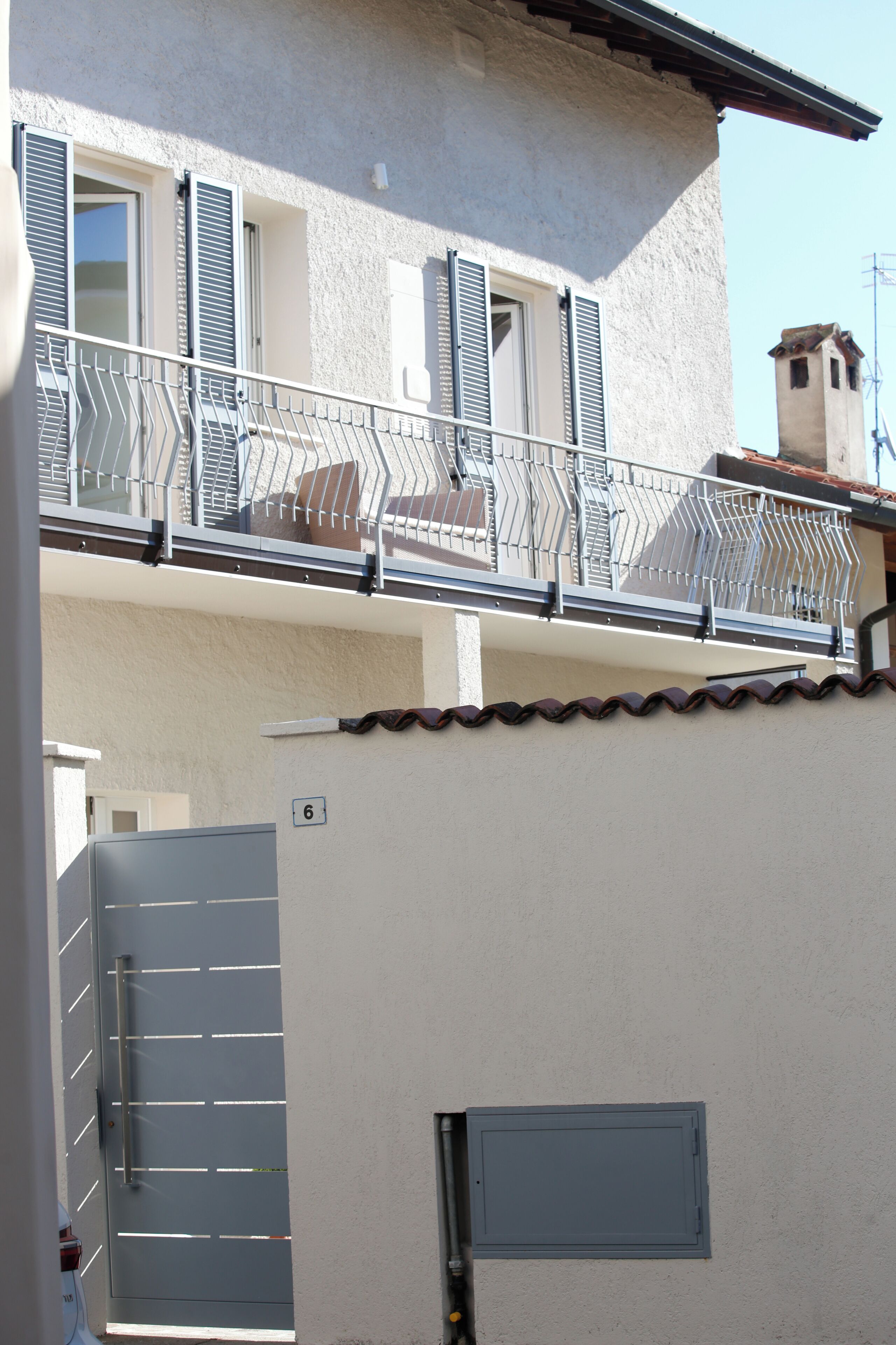 Un bâtiment doté d’un balcon, d’une porte et du chiffre « 6 » peint sur le mur.