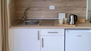 A kitchen with a sink, a coffee maker, and a dishwasher. - Estudio Nuevo con Jardín Privado en Pleno Valle (La Laguna)