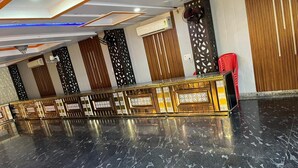 A spacious hall with a polished marble floor, a decorative railing, and a red chair. - Hotel Shivam Inn Agra (Agra)