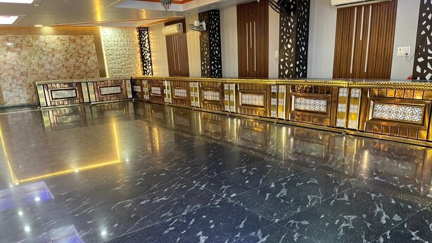A spacious lobby with a marble floor, a reception desk, and decorative panels. - Hotel Shivam Inn Agra (Agra)