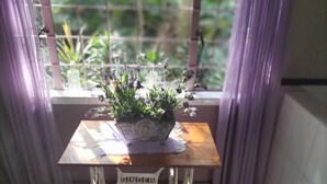 Een tafel met een potplant voor een raam met gordijnen.
