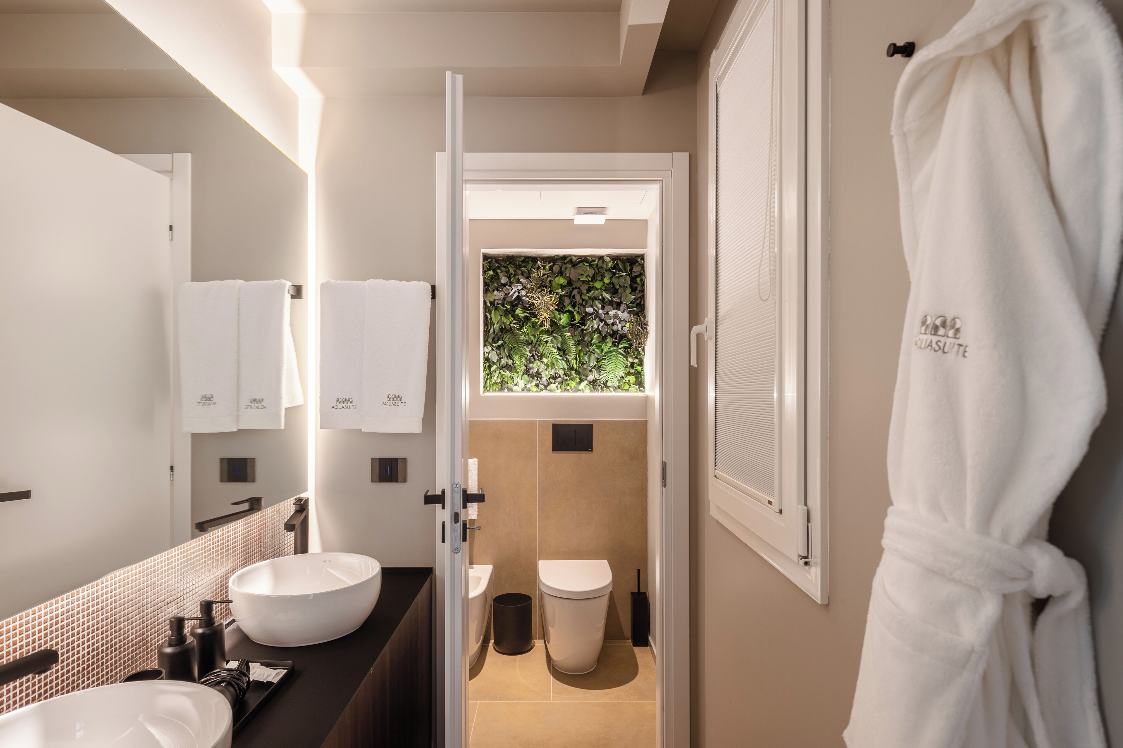 Une salle de bain moderne avec un grand lavabo blanc, un miroir et un porte-serviettes.