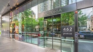 A modern building with a glass facade, the name "VICTORIA" prominently displayed above the entrance.