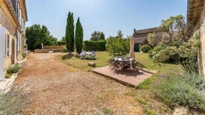 A courtyard with a gravel path, outdoor seating, and a stone building. - Property XVIII of 500 m2 with private pool and park 20 minutes from Bordeaux. (Virsac)