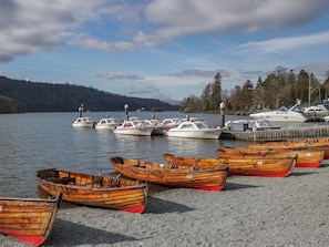 A marina with several wooden boats and a few motorboats docked. - Highfield Cottage (Windermere)