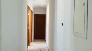 A narrow hallway with tiled flooring and white walls. - Dar sfar with sea view (Mahdia)