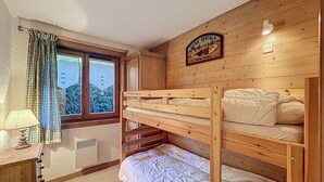A bunk bed room with a window, a lamp, and a sign indicating car rental services.