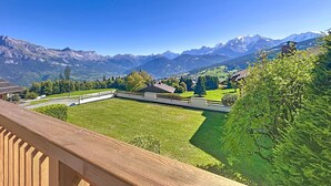 A view from a balcony overlooking a mountainous landscape with a clear sky.