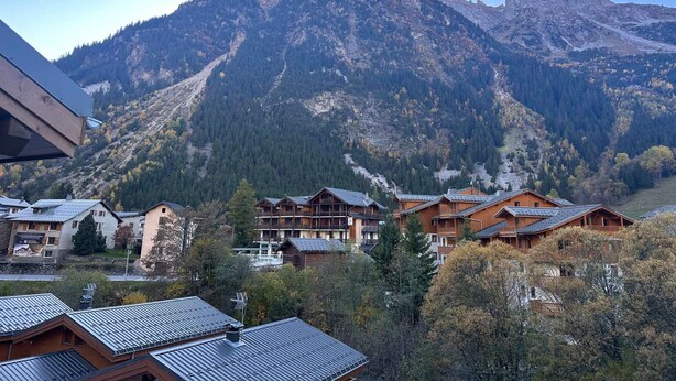 A mountain resort with wooden cabins and a ski slope.