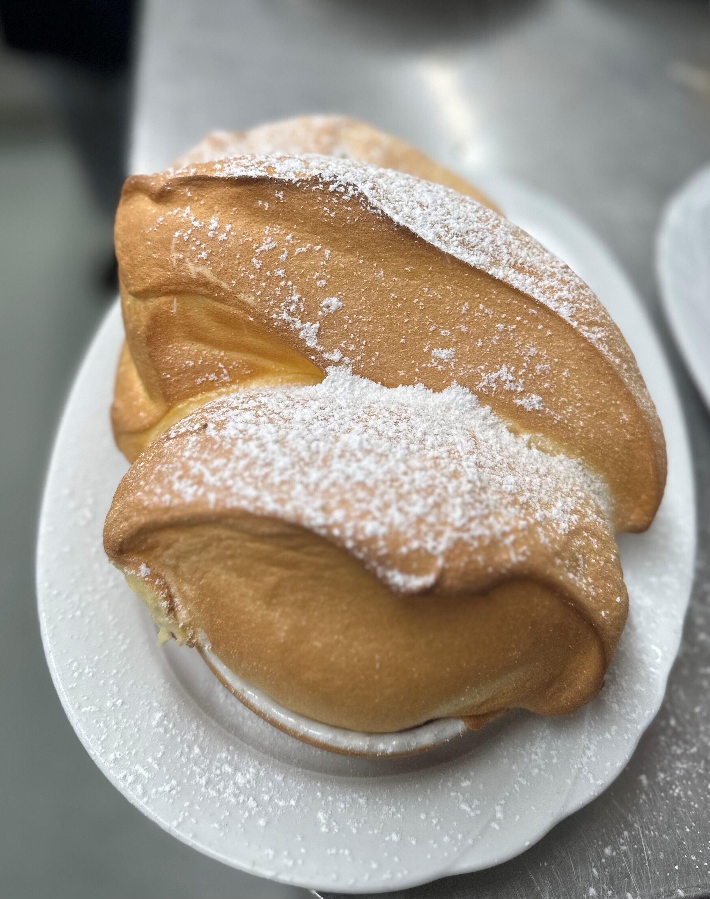 Une assiette contenant deux pâtisseries saupoudrées de sucre glace.