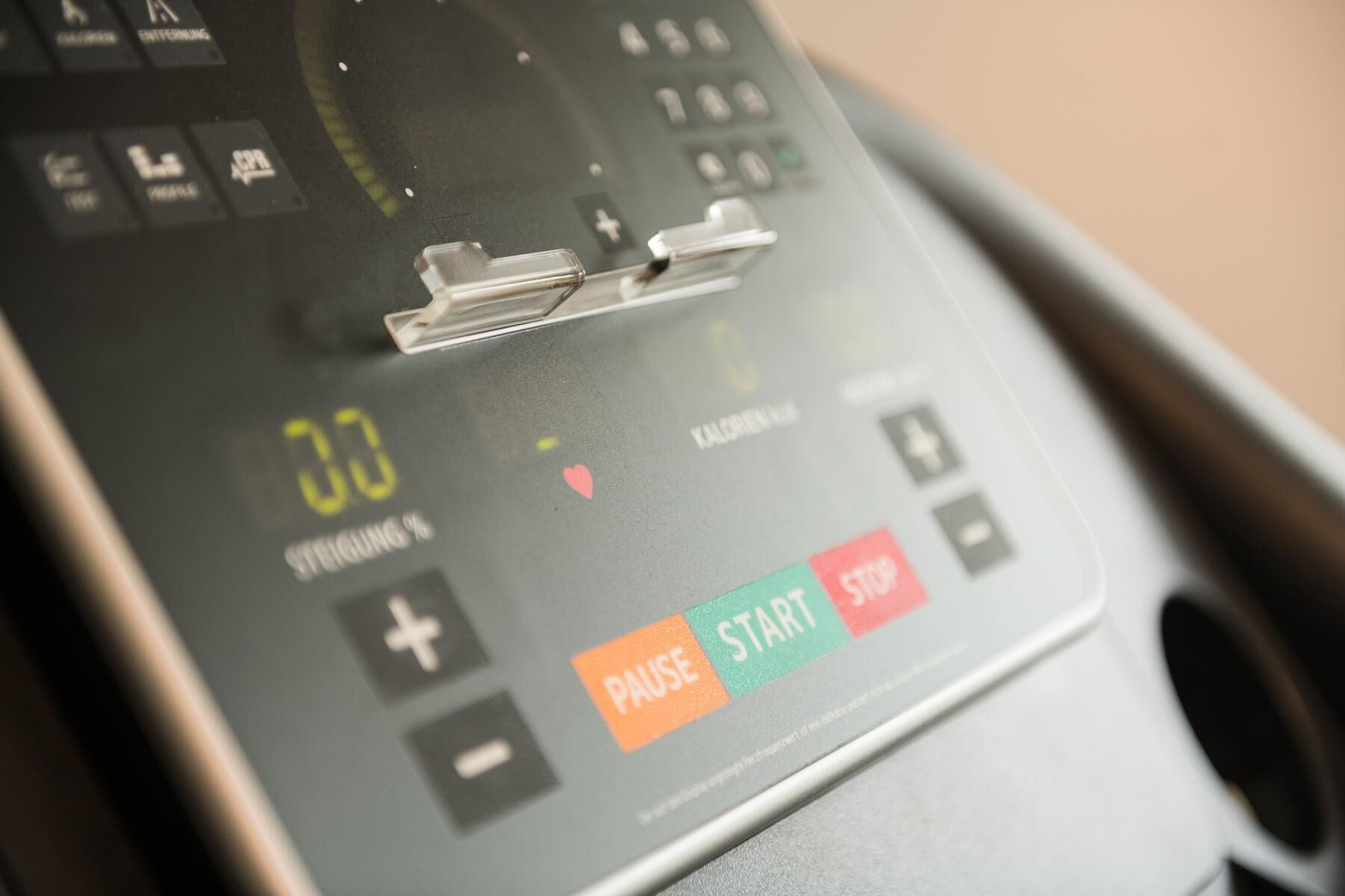 A close-up of a digital device with a display showing '00' and a heart symbol, along with 'PAUSE' and 'START' buttons.