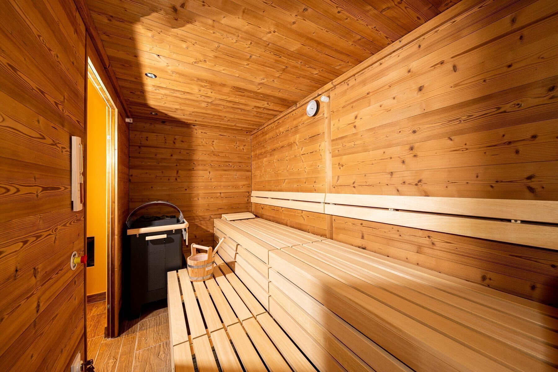 Un cuarto de sauna con bancos de madera y un calentador.