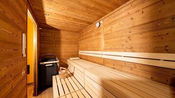 Un cuarto de sauna con bancos de madera y un calentador.