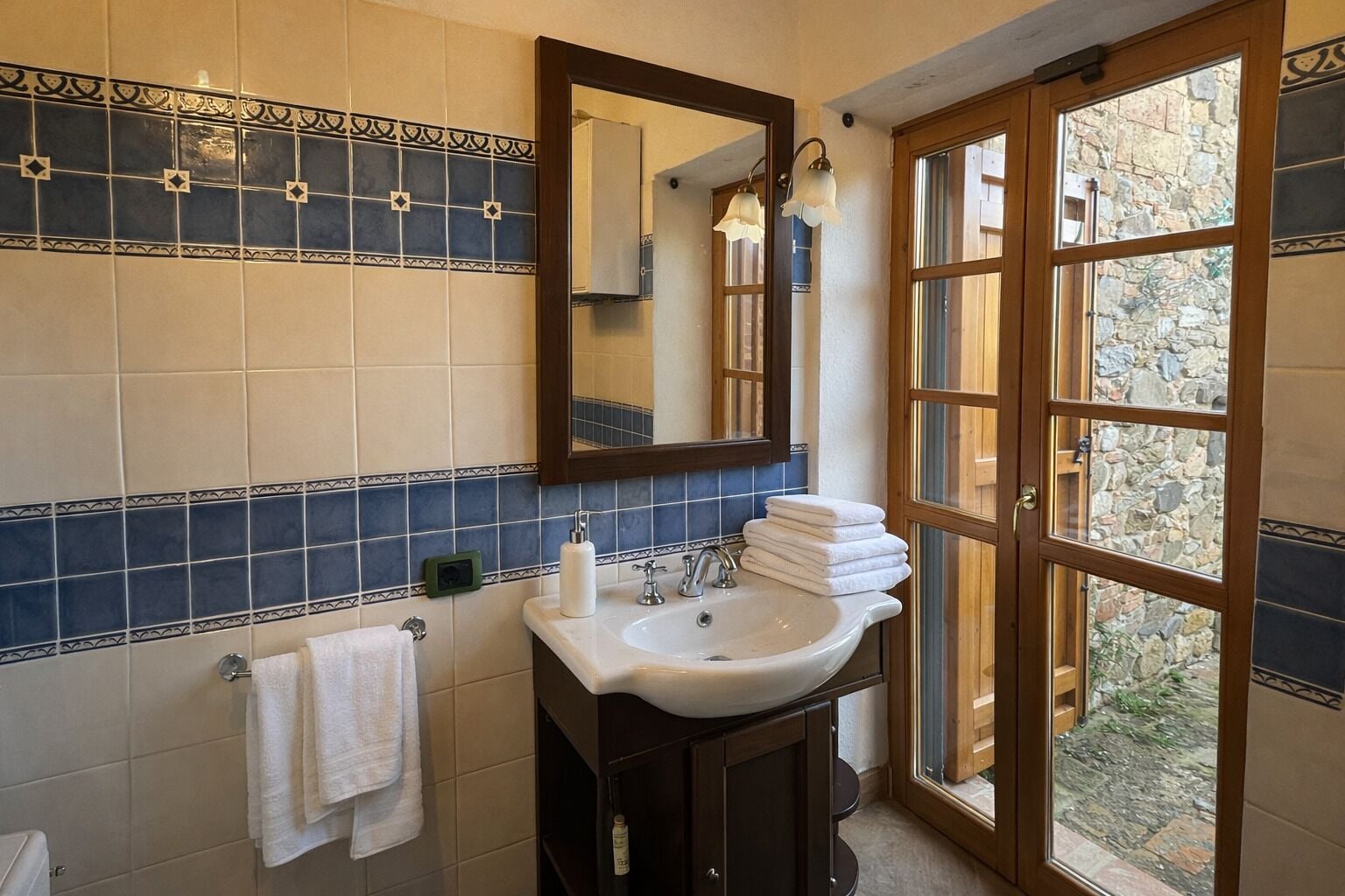 A bathroom with a sink, mirror, and towel rack.