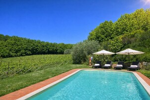 Una piscina al aire libre de temporada, sombrillas