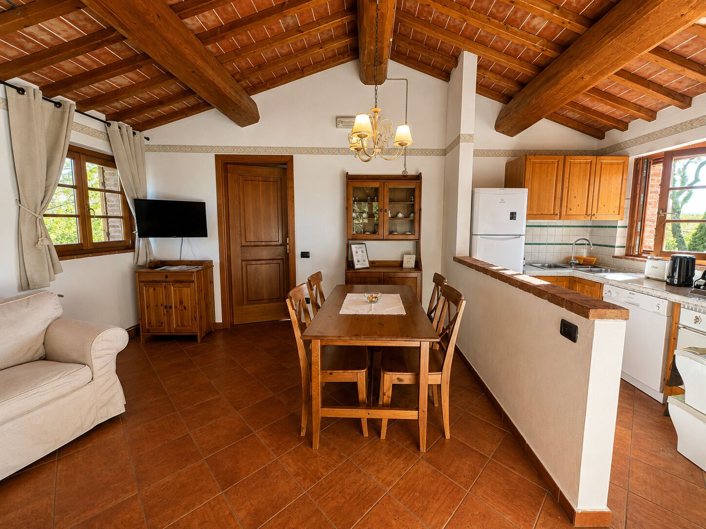 Uma cozinha aconchegante com armários de madeira, uma mesa de jantar e um forno embutido.