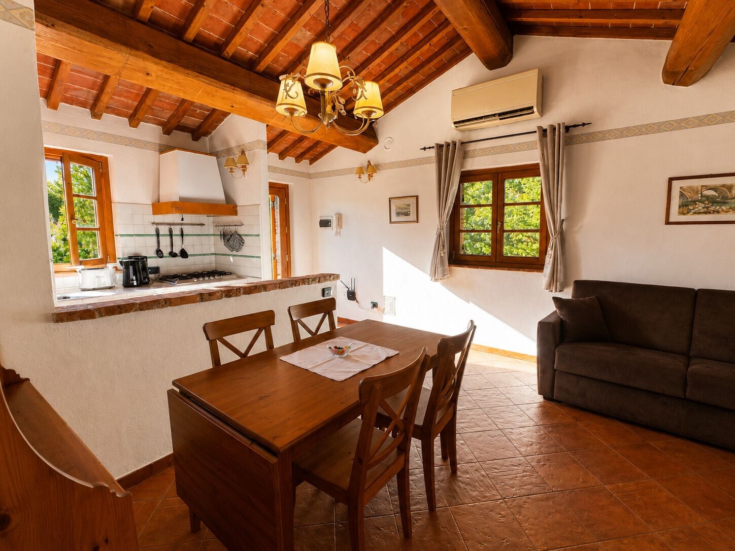 Un comedor con mesa y sillas de madera, una cocina con estufa, y una sala de estar con sofá.