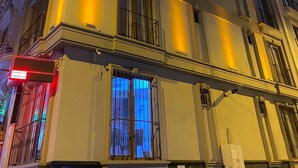 Un edificio de varios pisos con balcones y ventanas grandes, iluminado por una luz cálida.
