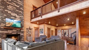 A spacious living area with a fireplace, a large sectional sofa, and a balcony.