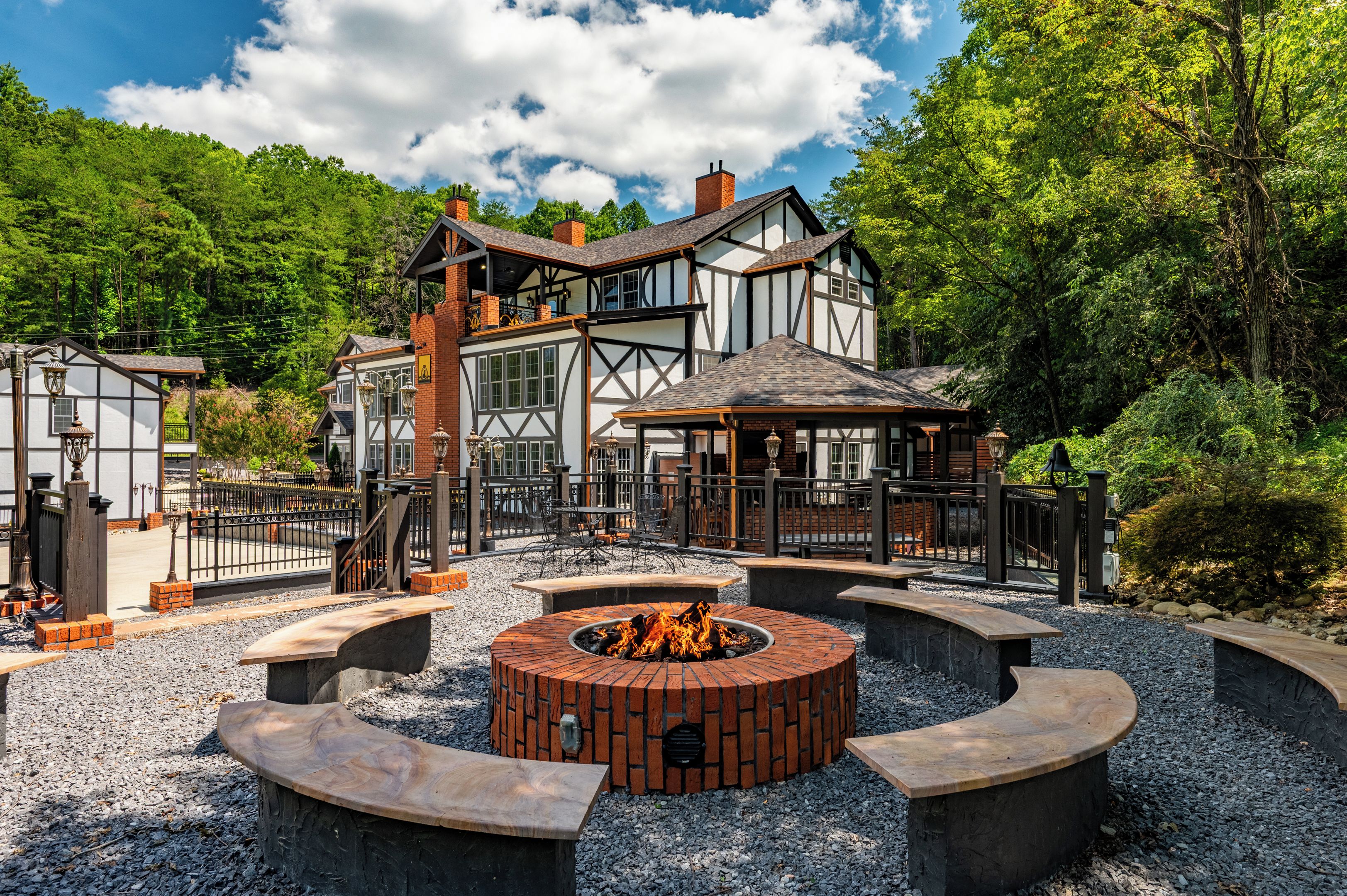A traditional building with a large patio area featuring a circular fire pit and seating.
