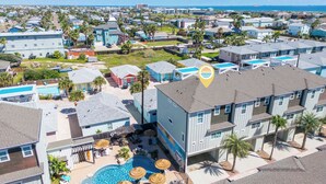 A residential area with multiple two-story houses, a swimming pool, and a beach view. - Spacious TownHouse ~ Walk to Beach ~ Resort Pool (Port Aransas)