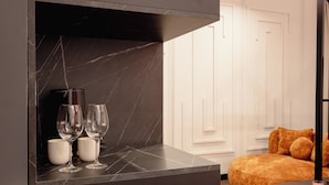 A modern room with a marble countertop, two wine glasses, and a white mug. - Kron (Novi Sad)