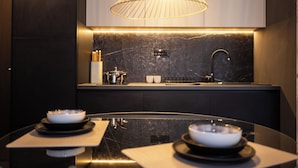 A modern kitchen with a marble countertop, a sink, and a pendant light. - Kron (Novi Sad)