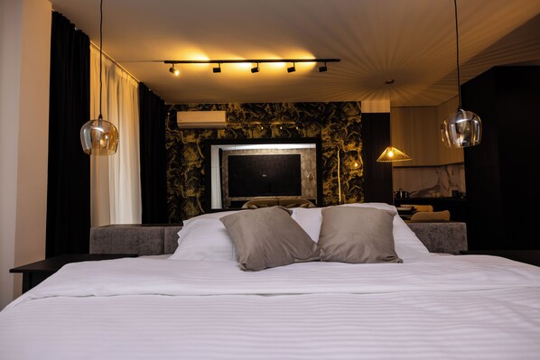Une chambre d’hôtel moderne dotée d’un grand lit, d’un téléviseur à écran plat et d’un éclairage d’ambiance.