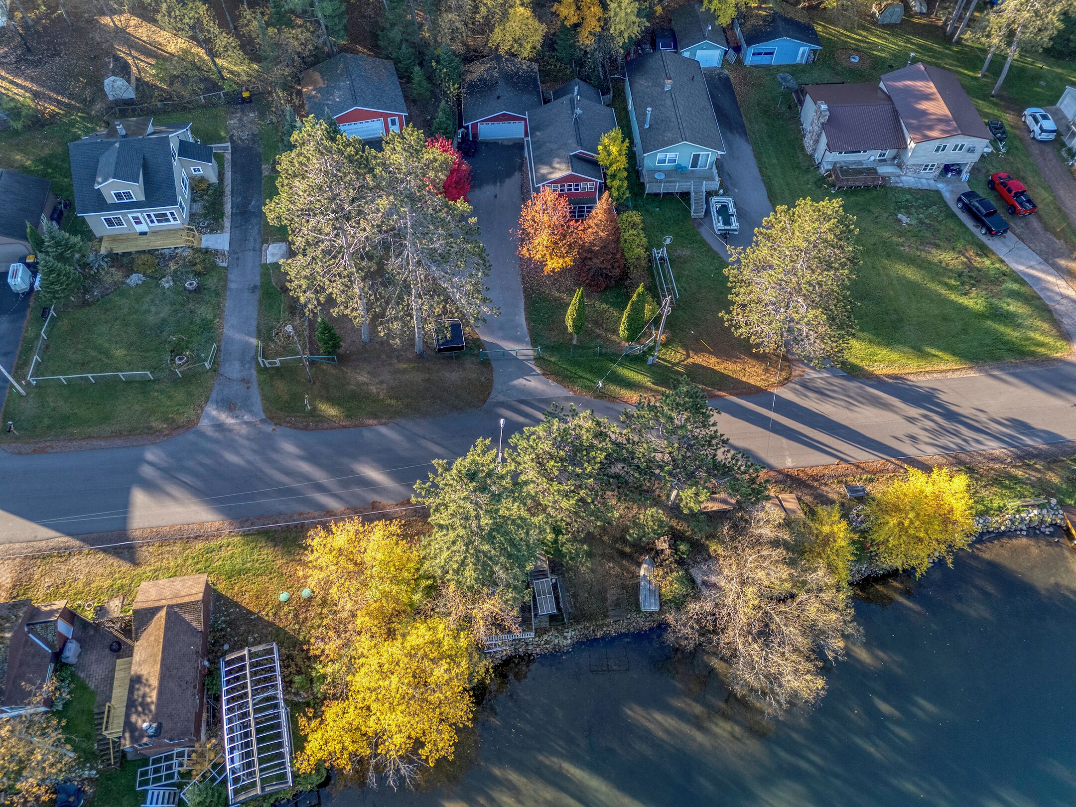 An aerial view of a residential area with houses, roads, and trees.
