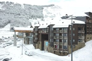 A multi-story hotel with balconies, a ski lift, and a snowy mountain backdrop. - Résidence Vacancéole - Privilège (Germ)