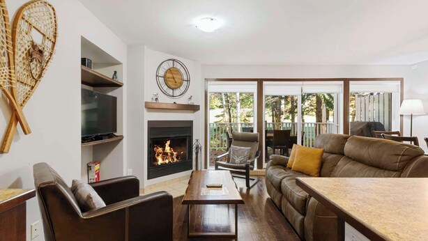 Una sala de estar con chimenea, televisor y sofá.
