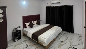 Un dormitorio moderno con una cama, un ventilador de techo y suelo de mármol.
