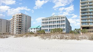 A beachfront hotel with multiple floors, balconies, and a beach in the foreground. - Ambassador Villas 401 Oceanfront 7 Br 6 Ba (North Myrtle Beach)