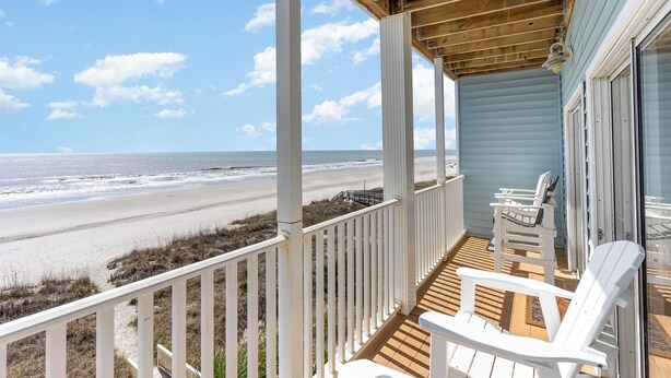 A wooden deck with white railings overlooking a beach. - Ambassador Villas 401 Oceanfront 7 Br 6 Ba (North Myrtle Beach)