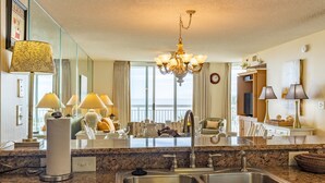 Eine Hotelküche mit einer Granit-Arbeitsplatte, einer Edelstahl-Spüle und einem Kronleuchter.